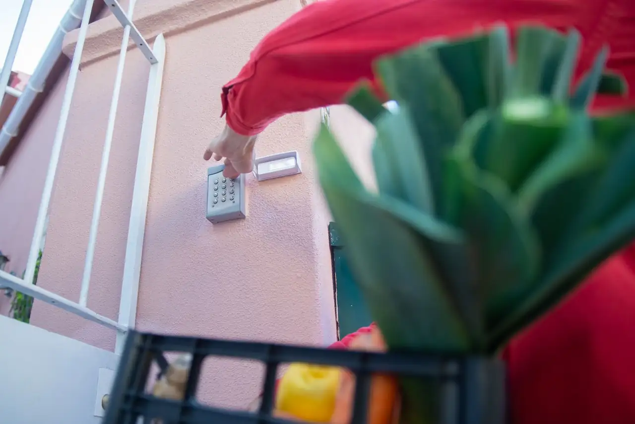 Close-up of a person using a security keypad on a gate, highlighting home access control.